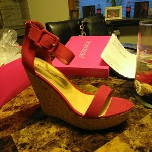 A pair of open toe boots and a pair of red wedges